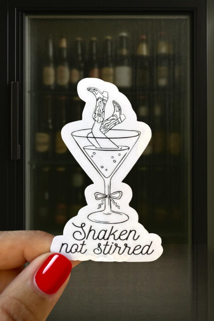 Sticker showing legs in high heels sticking out of a martini glass, with the phrase “Shaken not stirred.”