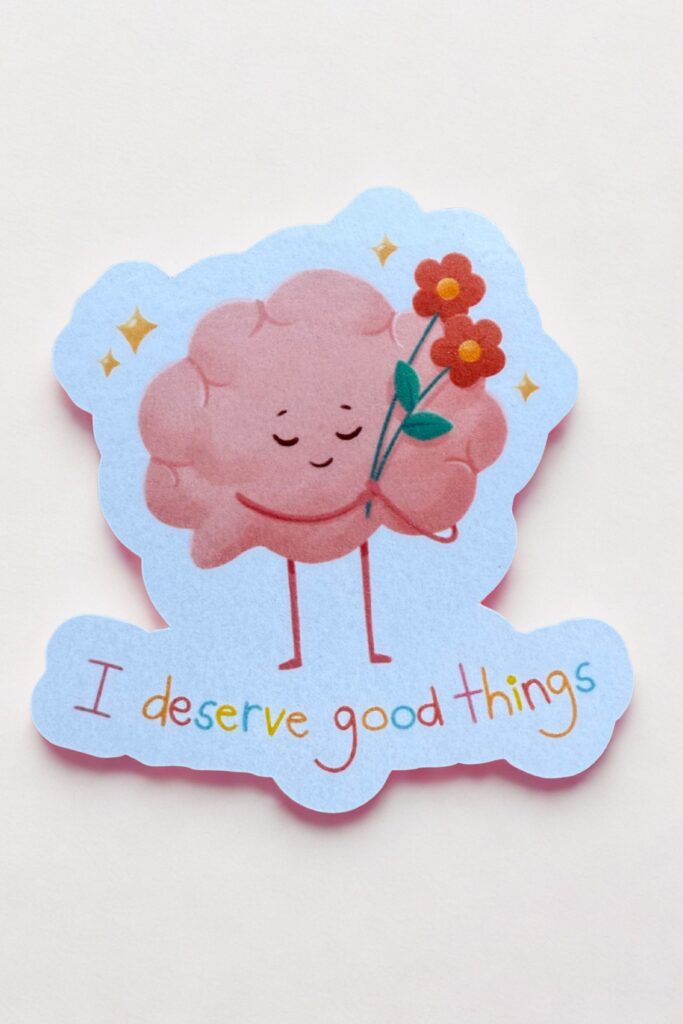Cartoon brain holding a bouquet of red and orange flowers, surrounded by yellow stars, with the phrase “I deserve good things” in colorful text—promoting self-worth and emotional wellness through cheerful illustration.